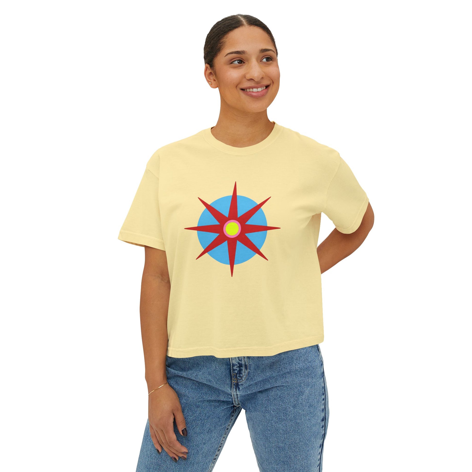 Melammu 8-point star boxy tee in Butter — red 8-point star on a light blue circle with yellow centre, navy Melammu logo on back